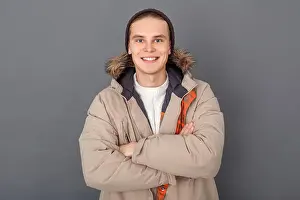 Studio One Prints: Young guy wearing winter clothes studio isolated on grey wall looking camera crossed arms smiling joyful