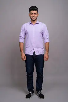 Stubble Prints: Young handsome Indian businessman against gray background