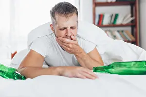 Awake Prints: Young handsome man in bed the morning after night out drinking