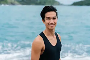 Tank Top Prints: Young happy smiling Eurasian man nearby the sea and looking at the camera