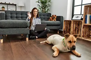 Calling Prints: Young hispanic woman having video call sitting on floor with dogs at home