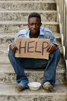 Homeless Prints: Young homeless African man with cardboard sign asking for help