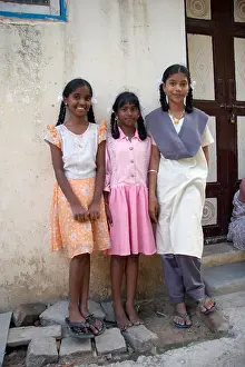 Three young Indian girls stand outside their home in Chennai Madras Tamil Nadu India