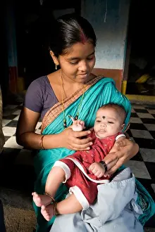 Orissa Prints: Young Indian mother with her son in her house at the fisherman village in Puri