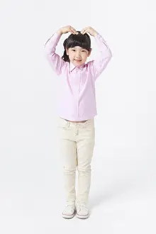 Korean Ethnicity Prints: Young Korean girl in pink shirt putting her hand up and making heart shape with arms
