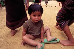 Inspirational Prints: A young laotian girl sitting on a ground in front of the playing children Muang Ngoi / Ban Na i northern Laos 2004