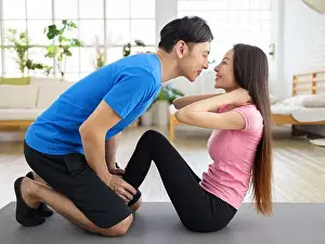 Homey Prints: Young man helping girlfriend to do crunches at home during quarantine