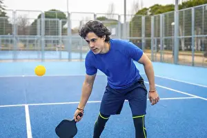 Paddle Prints: Young man holding a pickleball paddle