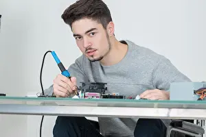 Repairman Prints: young man holding soldering iron
