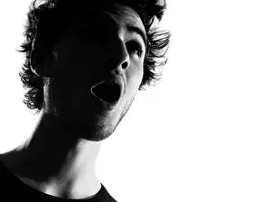 Shocked Prints: young man looking up portrait silhouette in studio isolated on white background