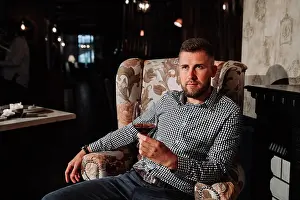 Watches Prints: a young man sitting on a chair in an expensive restaurant and drinking wine