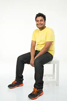 Grown Up Prints: Young man sitting on stool and smiling