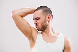 Odor Prints: Young man is smelling his armpit before shower