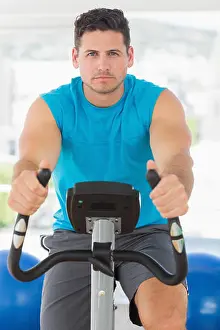 Stern Prints: Serious young man working out at spinning class