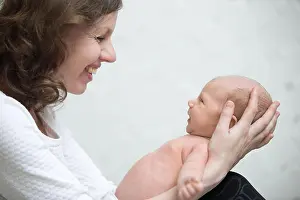 Childcare Prints: Young mother holding newborn cute babe