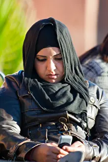 Maroc Prints: Young muslim woman using a cellphone in Marrakesh Morocco