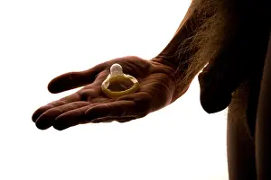 Contraception Prints: A young nude man holding a condom