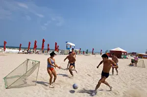 Hippy Prints: Young people playing football on a sandy beach, Vama Veche, Romania