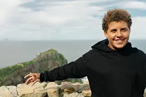 Childlike Prints: Young person stands at overlook near the ocean with a scenic view