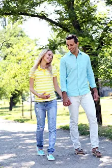 Fertility Prints: Young pregnant woman with husband walking in park