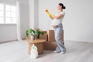 Cleanup Prints: Young pregnant woman with rubber gloves preparing for cleaning in new apartment
