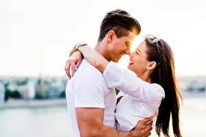 Young romantic couple hugging and about to kiss in beautiful sunset