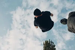 Stunt Prints: Young sporty guy doing parkour at the city street