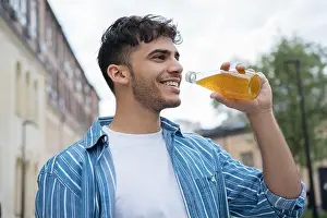 Casual Clothes Prints: Young stylish Indian man holding glass with drinks