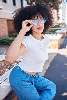 Mixed Race Prints: Young stylish mixed race woman with curly natural afro hair wearing trendy glasses outside