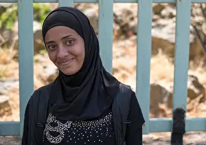 Young Syrian refugee girl in an hijab smiles in relief after crossing from Turkey to Lesvos in a rubber raft