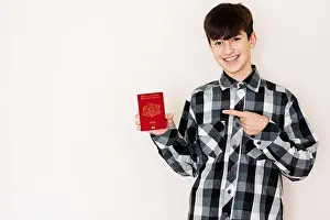 Glad Prints: Young teenager boy holding Latvia passport looking positive and happy standing