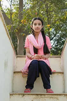 Leading Prints: Young village girl sitting on the steps of her house leading to the terrace