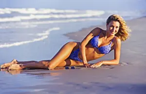 Miami Prints: Young woman at beach, laying on sand, sun tanning, Miami