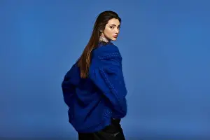 Formal Wear Prints: A young woman in a bright blue sweater, facing away from the camera