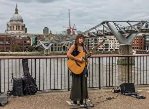 Entertain Prints: A young woman busker, singing and playing acoustic guitar