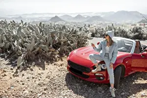 Convertible Prints: Young woman dressed casually with hat enjoying road trip on the island