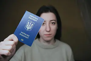 Ukrainian Prints: Young woman holding Ukraine passport in terminal of airport