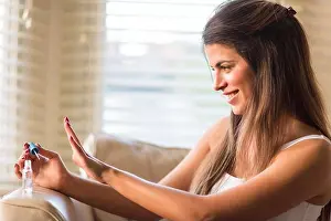 Nightwear Prints: Young woman looking at newly painted nails