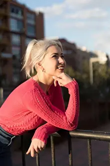 Radiant Prints: A young woman with platinum blonde hair smiles while leaning on a railing