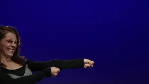 Pulling Prints: Young woman pulling on imaginary rope with determination against isolated blue background