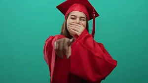 Robe Prints: Young woman in red graduation gown smiling and pointing against a vibrant green background