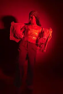 Intense Prints: A young woman in a red jacket and pants poses for a urban photo