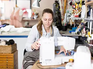 Reel Prints: Young woman sewer working with modern sewing machine