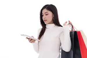 Shopper Prints: young woman shopping and using digital tablet isolated on a white background