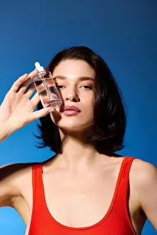 Rejuvenation Prints: Young woman showcases her glowing skin and skin care routine against a vibrant blue background