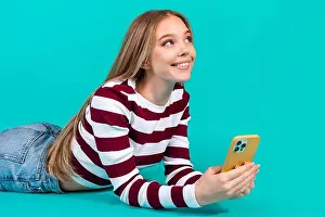 Girlish Prints: Young woman smiling with mobile phone in striped top blue background