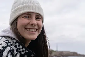 Dental Prints: Young woman smiling outdoors wearing winter beanie
