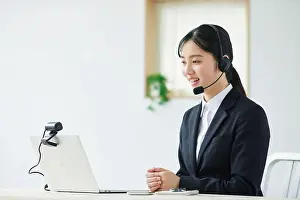 Young People Prints: Young woman in smiling suit with intercom speaking into laptop camera