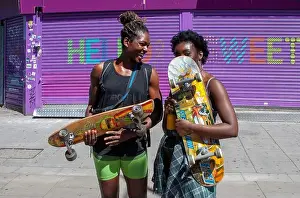 Camden Prints: Two young women holding skateboards on a hot summers day in London's Camden Town