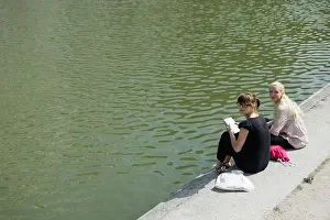 20 24 Years Prints: Young women sitting beside lake together